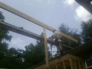 Carpenter setting a ridge beam over a new addition frame — Ice Dam Removal by Roofing Brothers in Mirror Lake