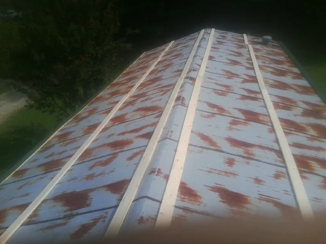 Rusted metal roof panels with new wood purlins before replacement — Storm Damage Roof Repair in Mirror Lake by Roofing Brothers