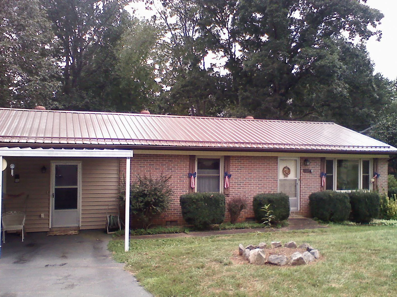 Bronze metal roof and carport on a brick ranch home — Roof Repair work by our crew in Mirror Lake