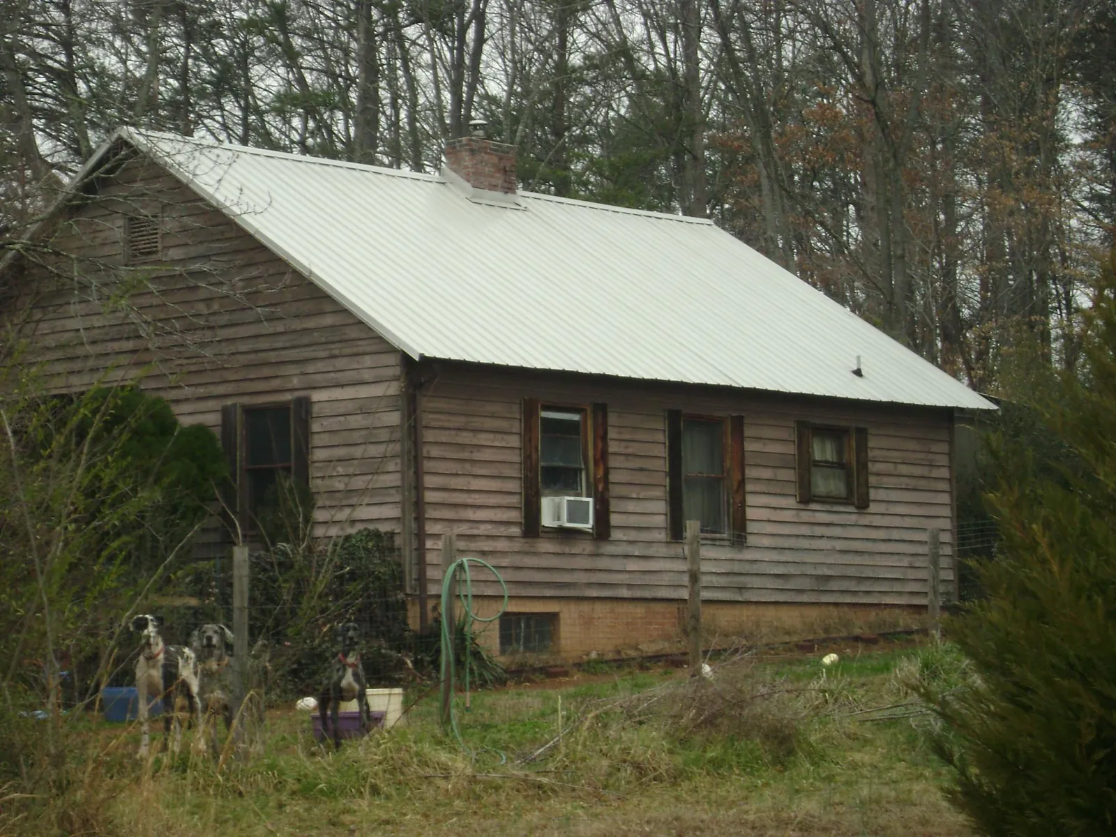 White metal roof on an old wood sided farmhouse, from a Metal Roof Installation job in Mirror Lake